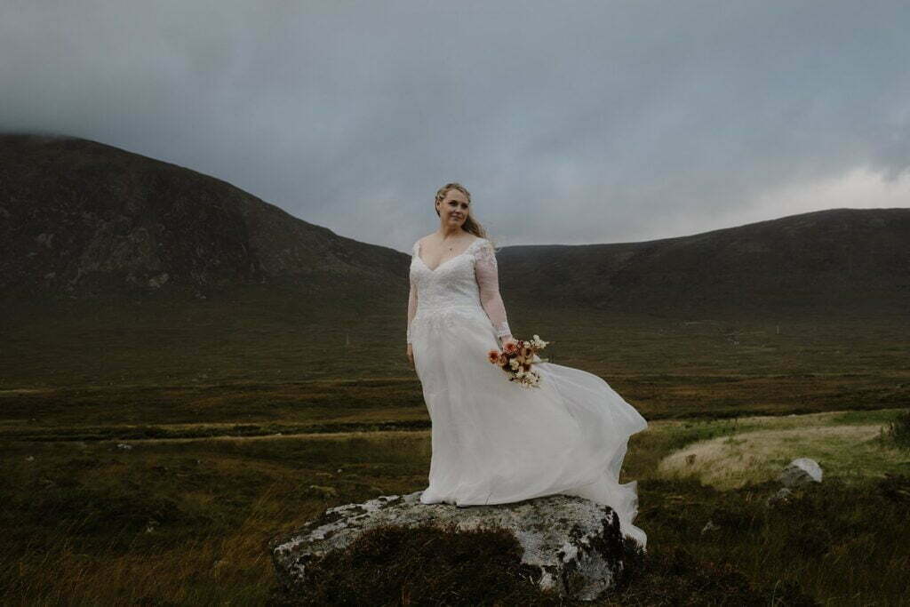 glencoe elopement photography outdoor bride flowing lace sleeve white wedding dress trees mountain mossy rock