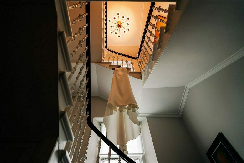 spiral staircase wooden banister modern chandelier white wedding dress