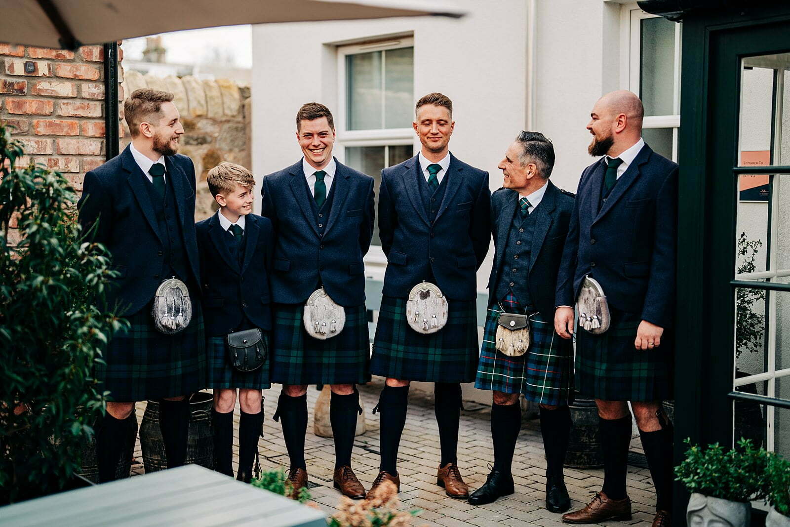 colourful forgans micro wedding outdoor champagne celebrations bride bridesmaids matching robes fluffy slippers groom groomsen navy suit jacket traditional kilt sporran