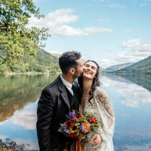 bride and groom kissing infront of mountains and lochs at scottish micro wedding