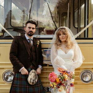 bride and groom looking moody and cool against vintage retro yellow bus organised by wedding planner scotland