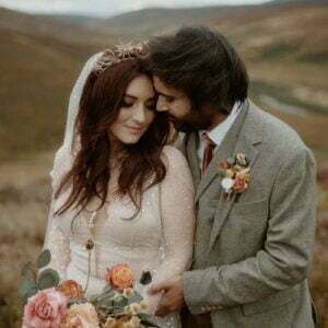 bride and groom cuddling at elopement on scottish moors highlands by coorie scotland wedding planner